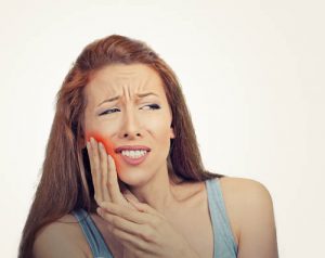 'woman in pain after wisdom teeth removal'